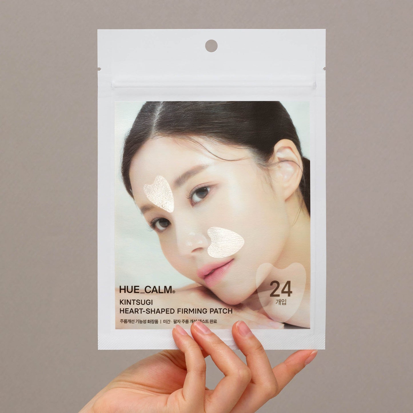 Hand holding Hue Calm Kintsugi Heart-Shaped Anti-Wrinkle Patch pouch – Korean vegan skincare packaging with heart-shaped lifting patches for face
